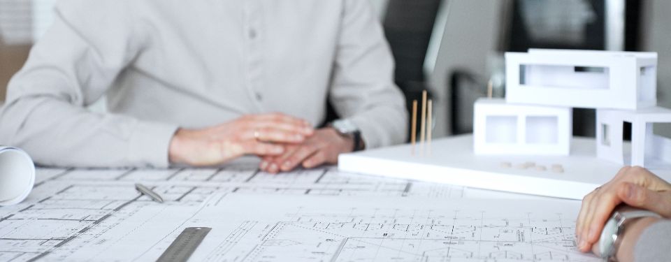 Persons looking over a building schematic, getting ready to prepare a construction bid.